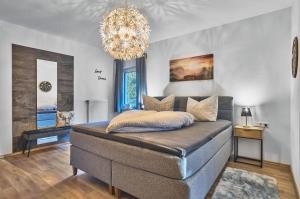 a bedroom with a large bed with a chandelier at Ferienwohnungen Geiger in Bodenmais