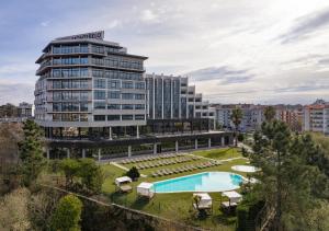 a large building with a swimming pool in front of it at Montebelo Viseu Congress Hotel & Spa in Viseu