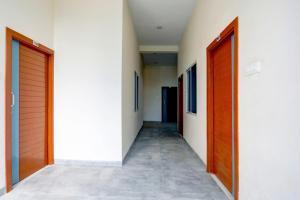 a hallway with two wooden doors and a hallway sidx sidx at Hotel O Grand Embassy in Mānglia