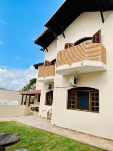 a white house with a balcony and a yard at Casa Família Silva próximo ao Santuário Nacional in Aparecida