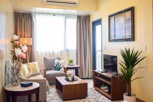 a living room with a couch and a tv at Seaview Apartment with Pool at Lapu-Lapu City in Punta Engaño