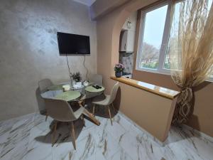 a dining room with a table and chairs and a television at Апартамент Михаел in Vidin +7 photos