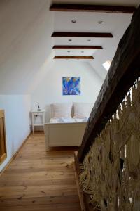 um quarto com uma cama e piso em madeira em Casa Paulini em Cisnadioara