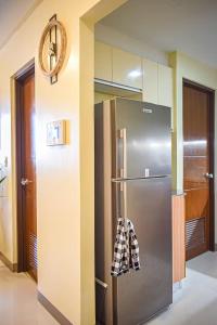 a kitchen with a stainless steel refrigerator and a clock at Seaview Apartment with Pool at Lapu-Lapu City in Punta Engaño