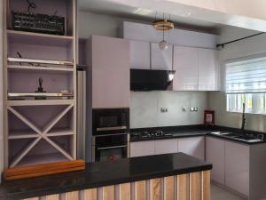 une cuisine avec des armoires blanches et un comptoir noir dans l'établissement Brandison Apartments, à Port Harcourt