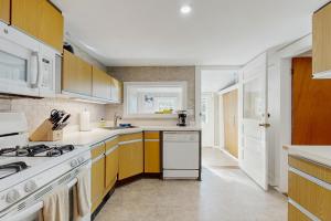 a kitchen with white appliances and yellow cabinets at Ledgewood 7 in Seal Harbor