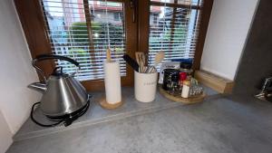 a kitchen counter with a window with a tea kettle and utensils at Apartmán Mája in Rumburk
