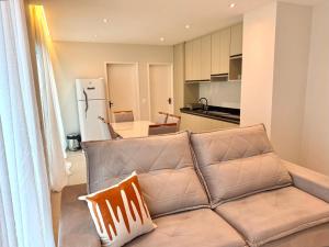 un salon avec un canapé et une cuisine dans l'établissement Apartamento mobiliado Beira-Mar, à Maragogi