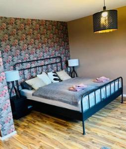 een slaapkamer met een bed met een bloemenmuur bij CS HARZgeflüster-Das Familienhotel in Thale