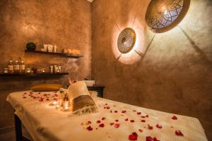 a room with a table with red rose petals on it at Riad Villa Wengé & Spa in Marrakesh