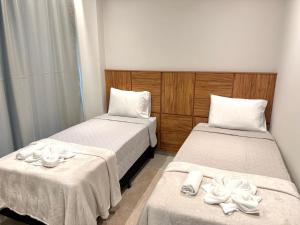 une chambre avec deux lits avec des serviettes dessus dans l'établissement Apartamento mobiliado Beira-Mar, à Maragogi
