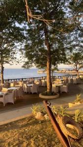 a restaurant with white tables and chairs on the beach at Seaview Apartment with Pool at Lapu-Lapu City in Punta Engaño