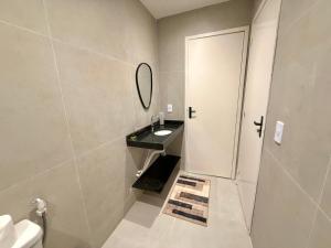une salle de bain avec un lavabo et un miroir dans l'établissement Apartamento mobiliado Beira-Mar, à Maragogi 13 autres photos