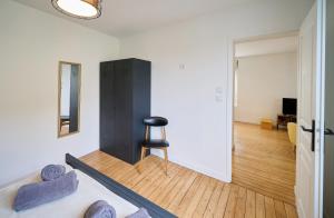 ルマンにあるLe Confort T2 tout équipé, proche Gare, Centre ville, Circuit des 24Hのベッドと黒いキャビネット付きの部屋