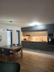 Una cocina con una mesa y un comedor. en Apartmány JARO Mladá Boleslav, en Bradlec