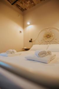 a bedroom with a white bed with towels on it at B&B Lilà in Chieti