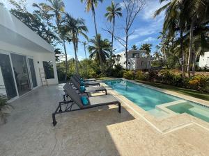 une piscine avec un banc à côté d'une maison dans l'établissement Charming Villa GUGI in Playa Coson, à Las Terrenas