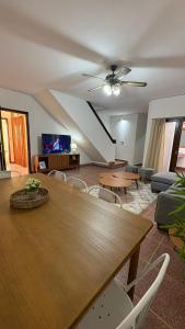 ein Wohnzimmer mit einem großen Holztisch und Stühlen in der Unterkunft Cerrito hou in Paysandú