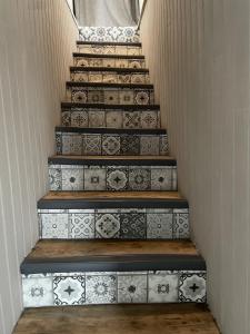 un escalier avec des carreaux blancs et noirs dans l'établissement Superbe Duplex de 2 Chambres au cœur de Gouvieux, à Gouvieux