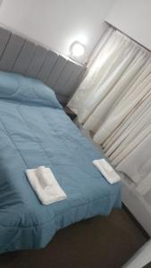 ein Bett in einem Zimmer mit zwei Handtüchern darauf in der Unterkunft Gran Hotel Avenida in Villa Gesell