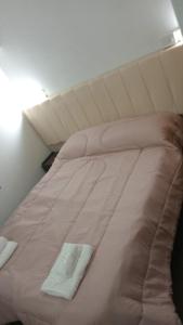 ein großes weißes Bett mit einem weißen Handtuch darauf in der Unterkunft Gran Hotel Avenida in Villa Gesell