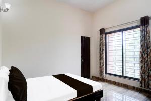 Un dormitorio con una cama y una ventana grande en Hotel O Oyasis.in, en Nagpur