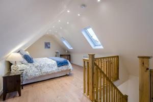 ein Schlafzimmer mit einem Bett und eine Treppe mit Oberlichtern in der Unterkunft 1 Bed in Rolvenden oc-c33657 in Rolvenden