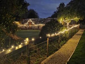 een hek met lichten voor een huis 's nachts bij 2 Bed in Latton oc-c34099 in Cricklade