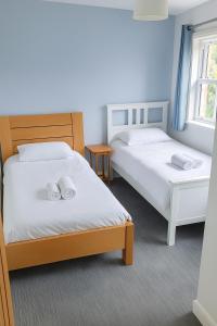 2 Betten mit weißen Handtüchern auf einem Zimmer in der Unterkunft Watercress Barns in Sittingbourne