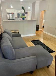 a living room with a grey couch and a kitchen at Jungle House Columbus Downtown Free Parking Sleeps 8 - Near Convention Center & Nationwide Arena - 2BR Short North Luxury Home - Over 5,800 Five Star Stays in Columbus