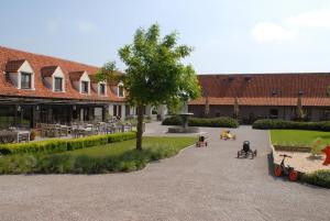 a group of people sitting on chairs in a courtyard at De Kruishoeve in De Haan