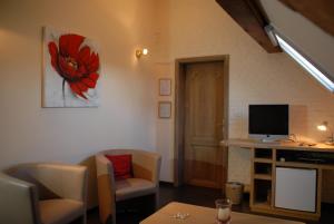 a living room with a desk with a television and chairs at De Kruishoeve in De Haan