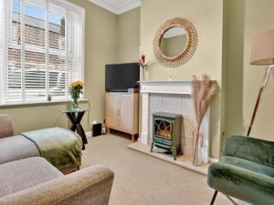 een woonkamer met open haard en tv bij Windsor Jay in York
