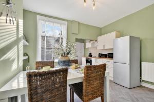 een keuken met een tafel met stoelen en een koelkast bij Windsor Jay in York