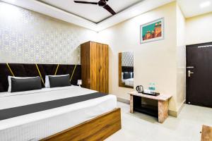 a bedroom with a bed and a table at Hotel O Barsana in Pātipukur