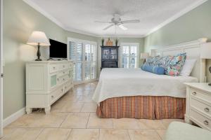 a bedroom with a bed and a ceiling fan at Beach Club #414 in Saint Simons Island +29 photos