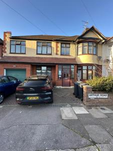 une voiture noire garée devant une maison dans l'établissement B&A House, à Romford