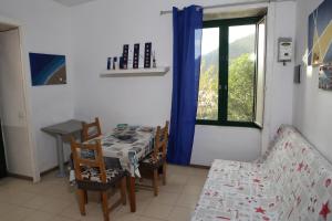 a dining room with a table and chairs and a window at Casa Rosa appartamento con giardino in Cetara