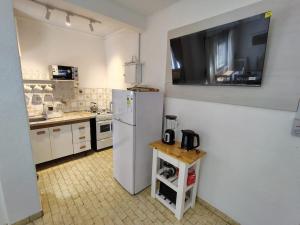 a kitchen with a white refrigerator and a table at Toninas Relax in Las Toninas