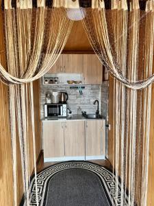 una cocina con cortinas y una cocina con fregadero en Sadiba Rozchil, en Yablunytsya