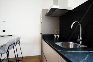 eine Küche mit einem Waschbecken und einer schwarzen Arbeitsplatte in der Unterkunft Alora Apartamentos Mérida in Merida + 12 Fotos