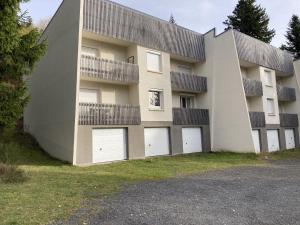 a building with four white garage doors in front of it at Cocon montagne Rocher du Cerf in Le Lioran