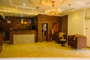 a lobby with two chairs and a chandelier at Proximus Hotel and Suites in Owerri