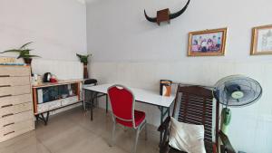 uma sala com uma escrivaninha e uma cadeira vermelha em Nana homestay em Phnom Penh