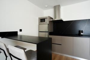 eine Küche mit einem schwarzen Tisch und einigen Stühlen in der Unterkunft Alora Apartamentos Mérida in Merida