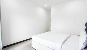 un lit blanc dans une petite pièce blanche dans l'établissement Hotel NH7 Near Patiala Chowk Bus stand Zirakpur, à Zirakpur