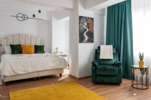a bedroom with a bed and a green chair at Apartament de închiriat Accommodation nr 10 in Suceava