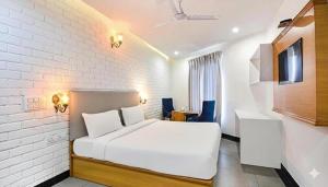 une chambre blanche avec un lit et un mur de briques blanches dans l'établissement Hotel NH7 Near Patiala Chowk Bus stand Zirakpur, à Zirakpur