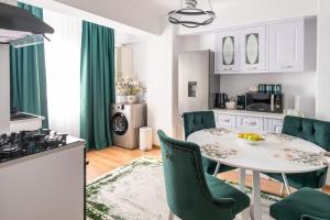 a kitchen with a white table and green chairs at Apartament de închiriat Accommodation nr 10 in Suceava