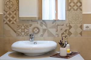 une salle de bains avec un lavabo blanc et un miroir dans l'établissement Domo Clelia, à Nulvi 15 autres photos